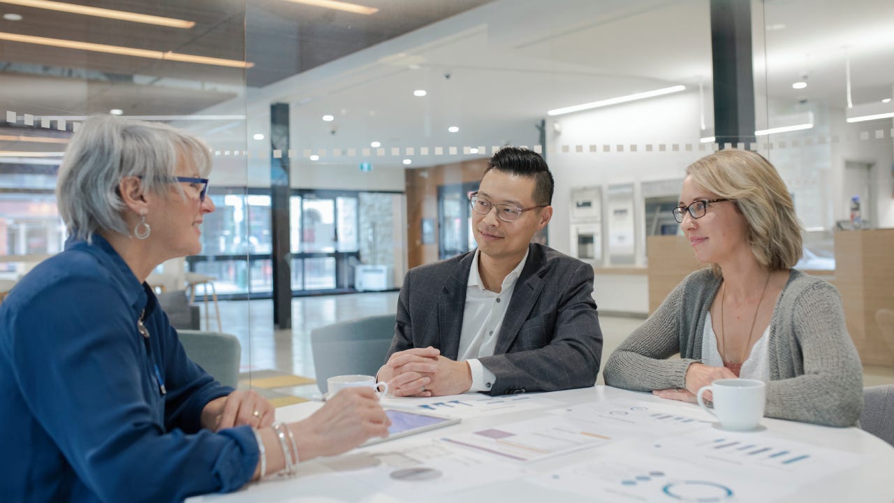 Loan manager meeting with couple in bank branch office