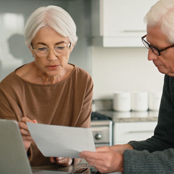 Senior couple, finance documents and computer for home mortgage, budget planning and pension or bills. Elderly woman and man on laptop, reading paperwork and asset management, loan or life insurance