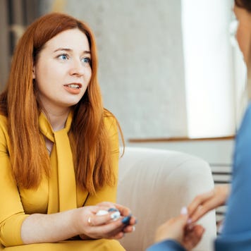 Two women in armchairs are sitting and talking