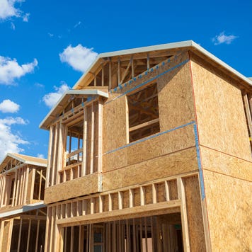 housing starts - new houses being built, wood frames against blue sky