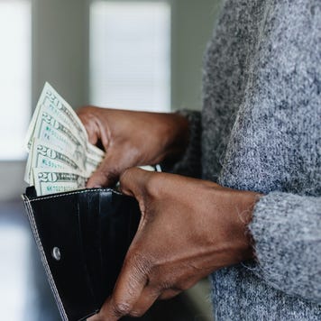 Woman Inserts Cash Into Wallet