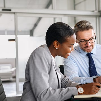 Business partners working on digital tablet in modern office