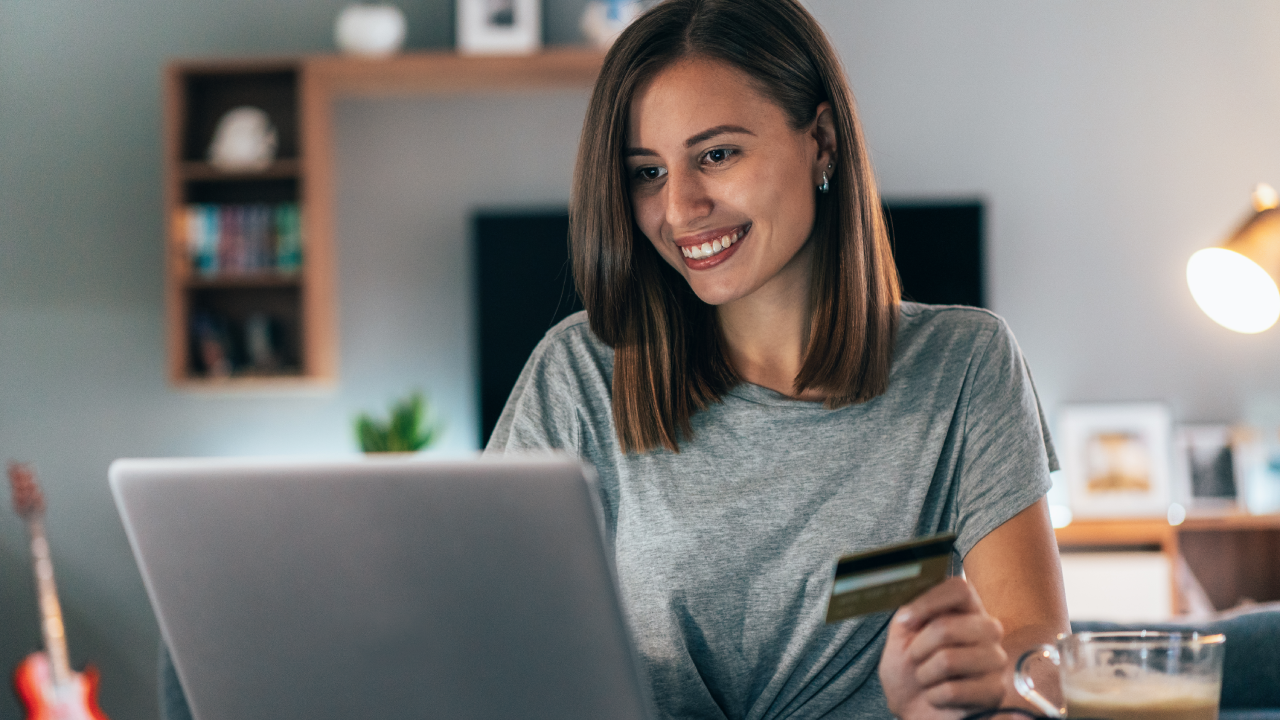 Young woman shopping online with credit card and lap top at home