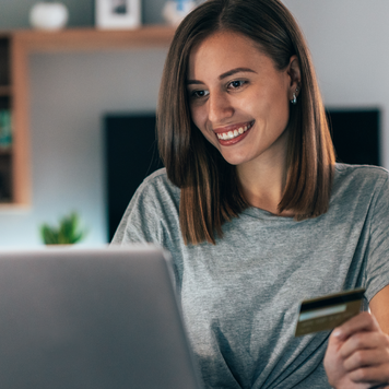 Young woman shopping online with credit card and lap top at home