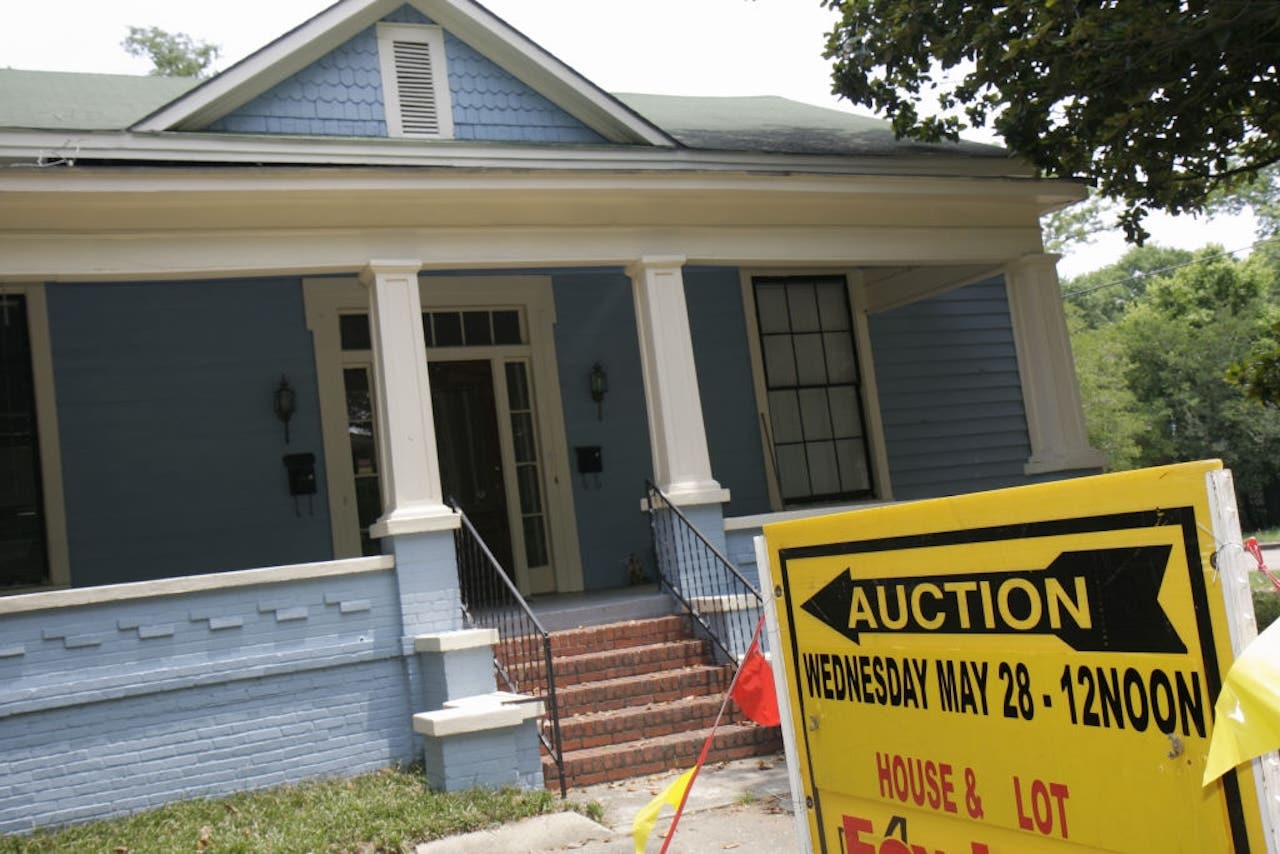 blue house being auctioned off, yellow auction sign out front