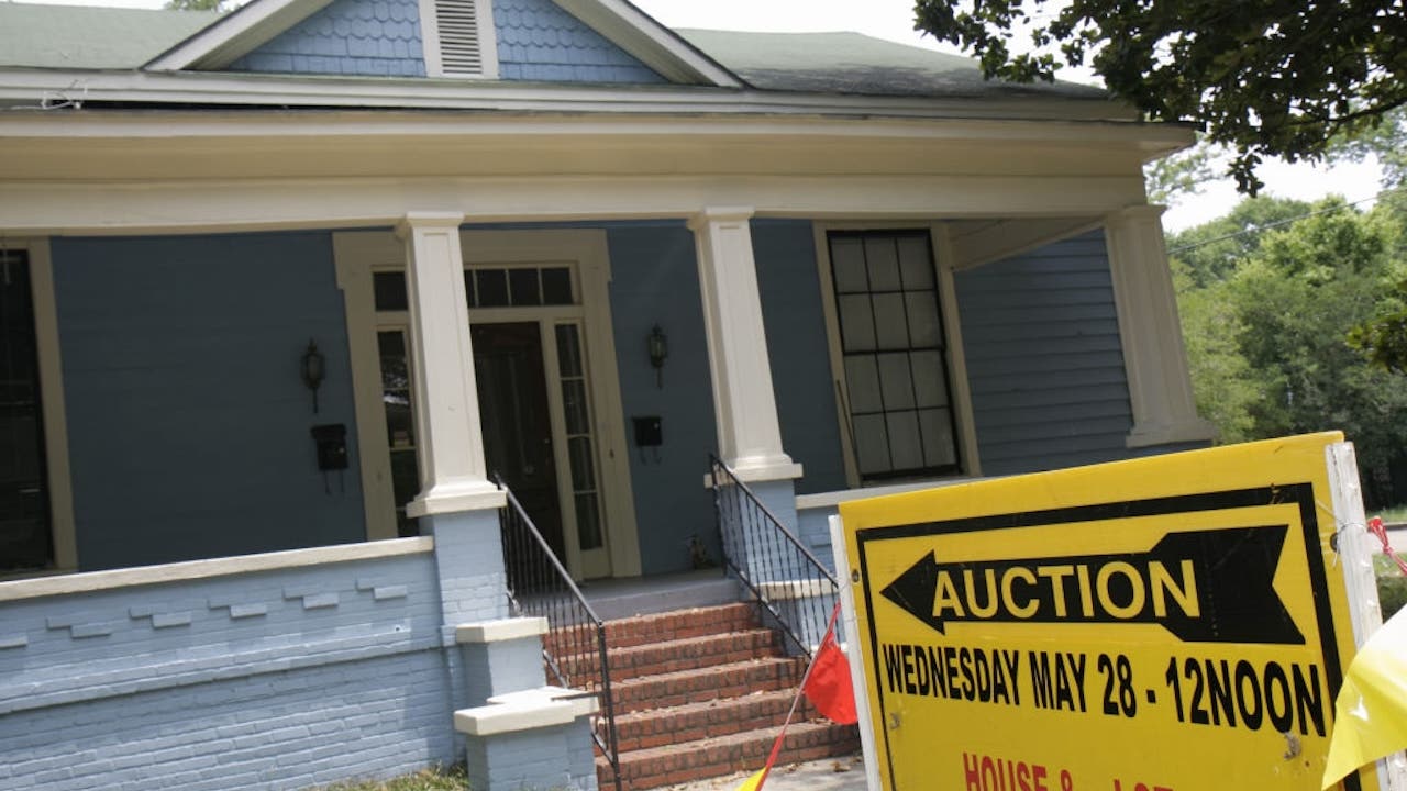 blue house being auctioned off, yellow auction sign out front