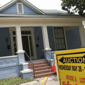 blue house being auctioned off, yellow auction sign out front