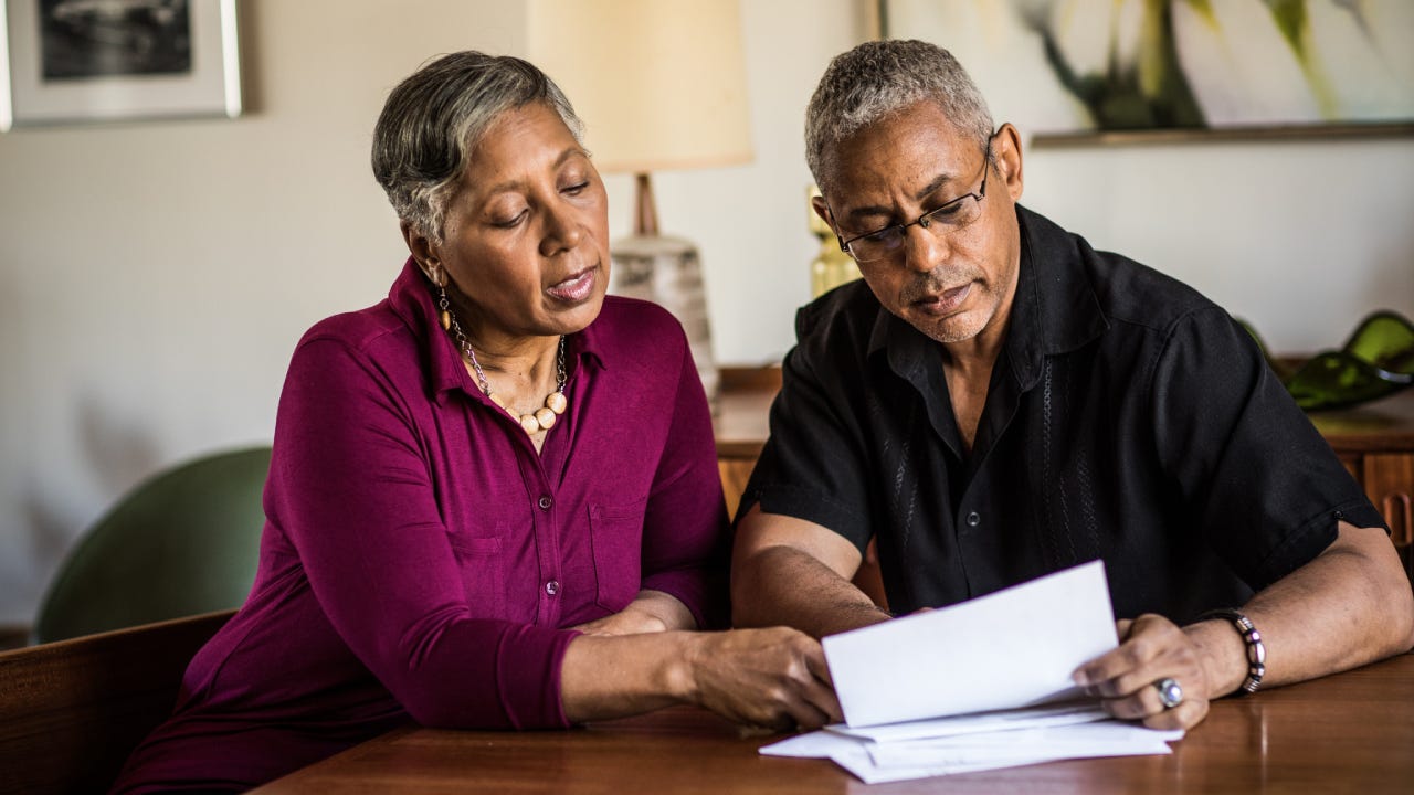 Senior couple (60yrs) paying bills at home