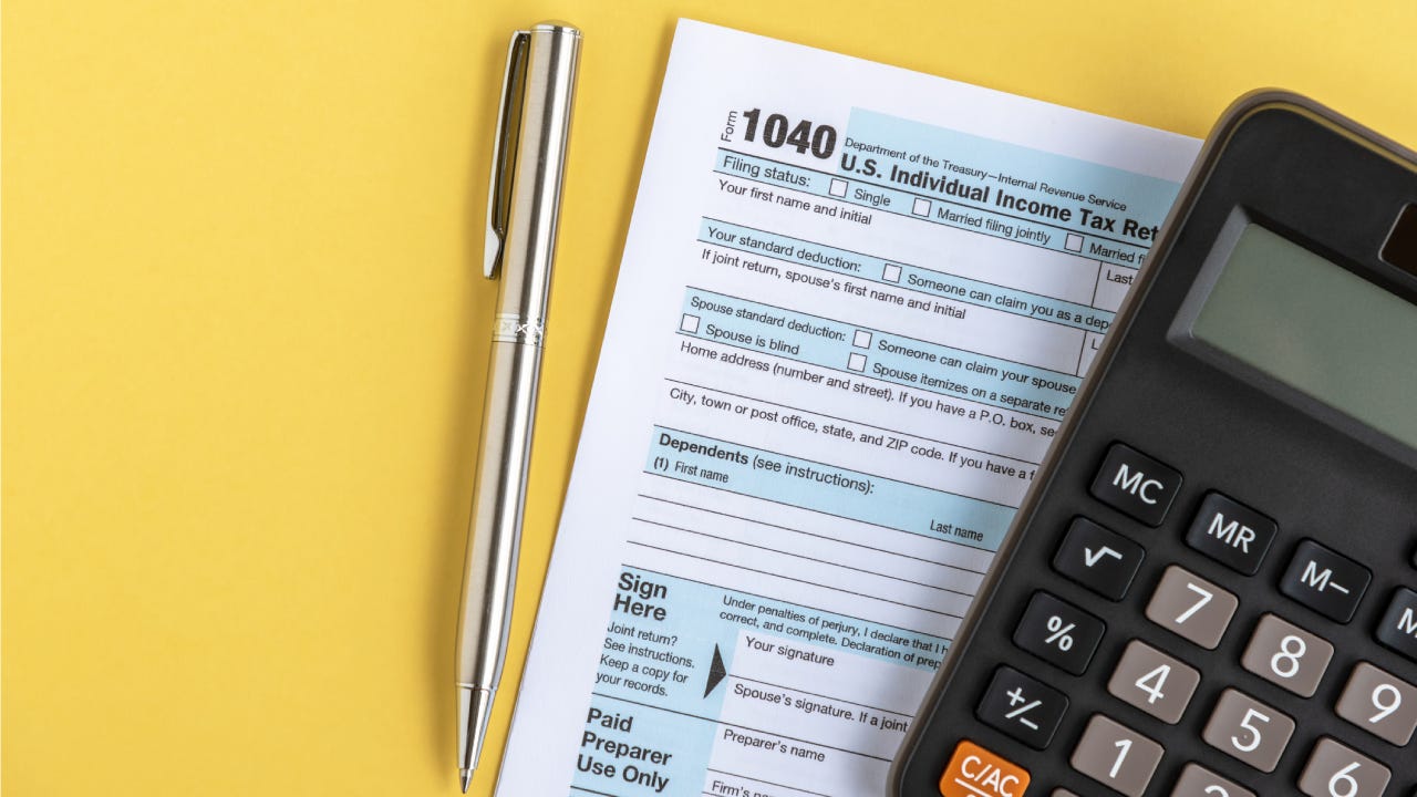 A U.S. IRS Form 1040 tax return alongside a pen and calculator
