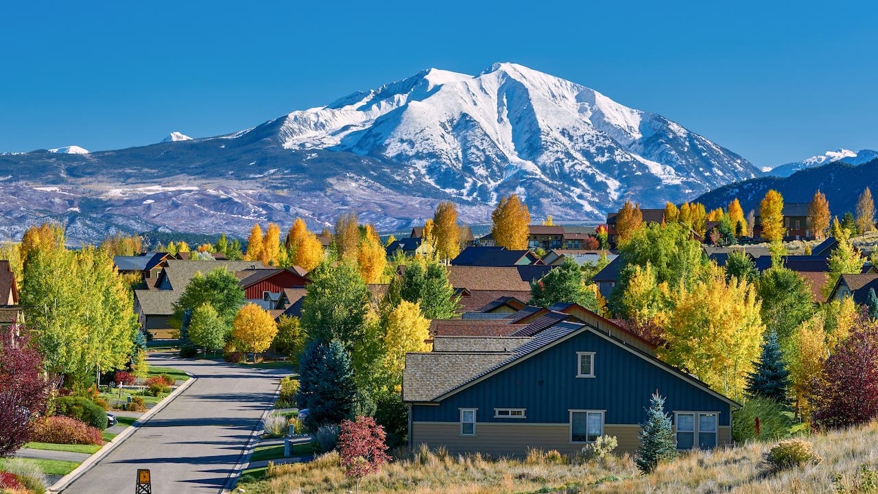homes in colorado with mountains in distance and fall leaves