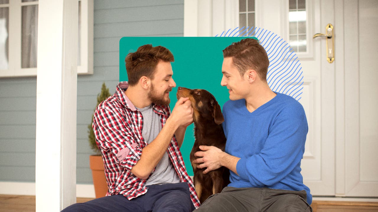 Two men sitting in front of a house with a dog