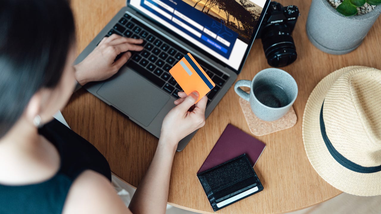 woman on laptop holding a credit card