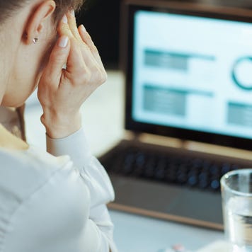 Seen from behind modern business woman having headache