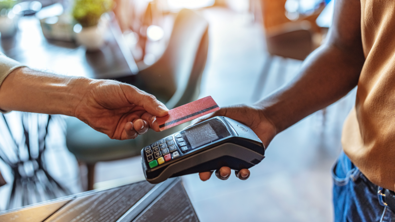 NFC Technology. Man giving credit card to waiter using modern contactless system at the bar