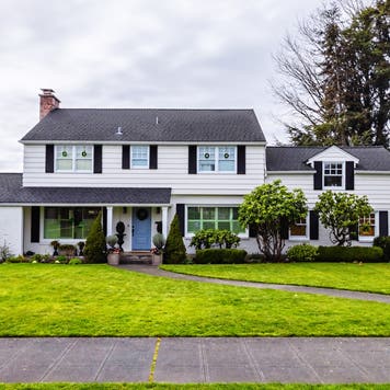 large white colonial style house exterior, green grass
