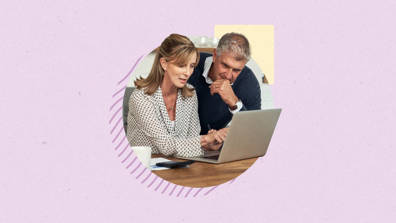 A woman working on a laptop and a man looking over her shoulder, paying close attention