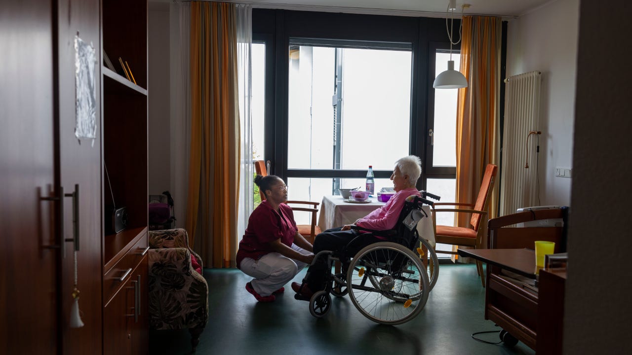 Inside of a nursing home, nurse and resident