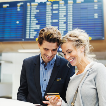 Happy business people looking at credit card in airport