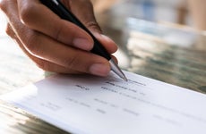 Close up shot of a hand signing a check