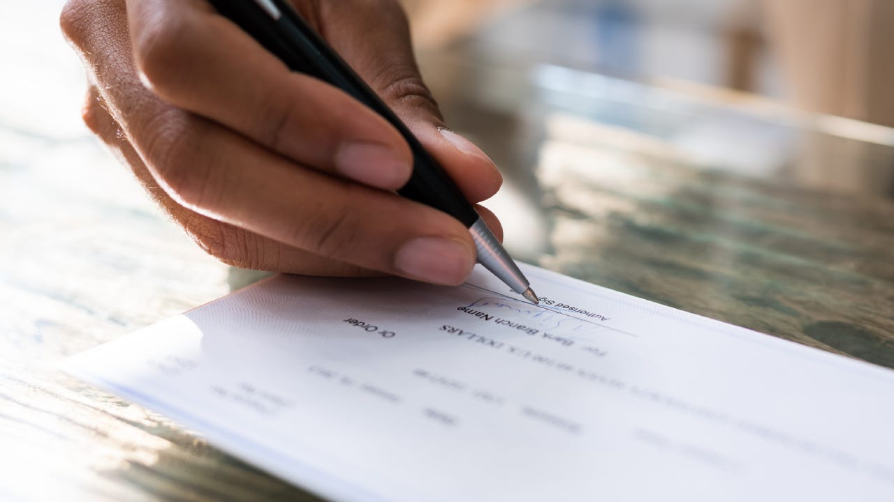 Close up shot of a hand signing a check