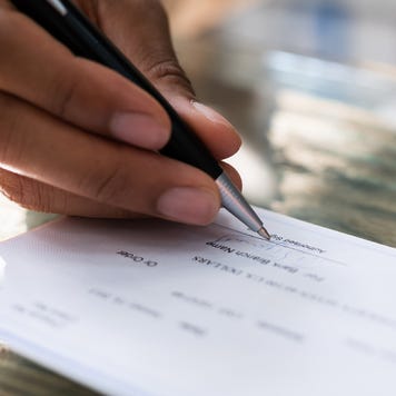 Close up shot of a hand signing a check