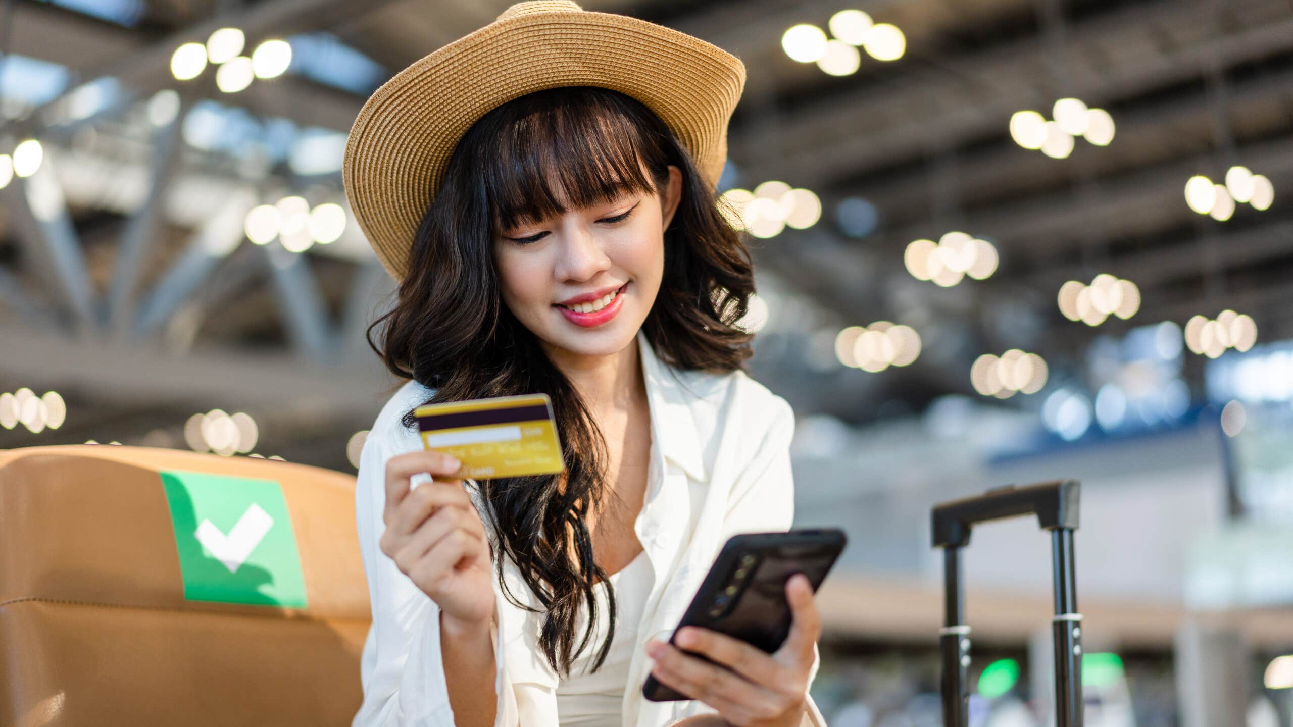 A girl using her smartphone to make a payment with a credit card.