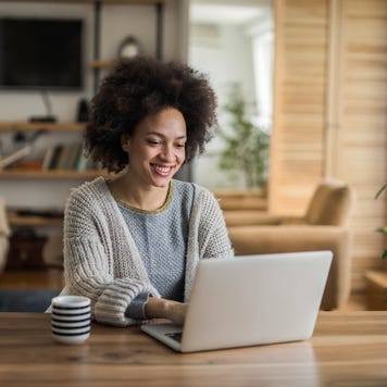 Woman at home doing online banking on a laptop