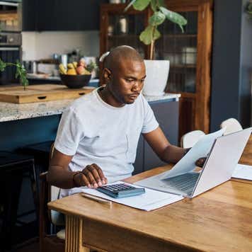 Businessman in his home with laptop and paperwork for financial planning