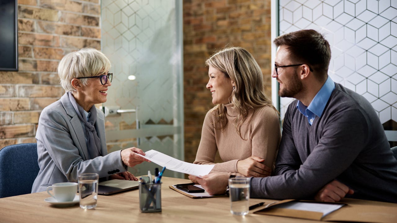 agent giving her customer paperwork while having a meeting in the office