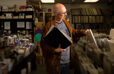 Small business owner stocking his record store.