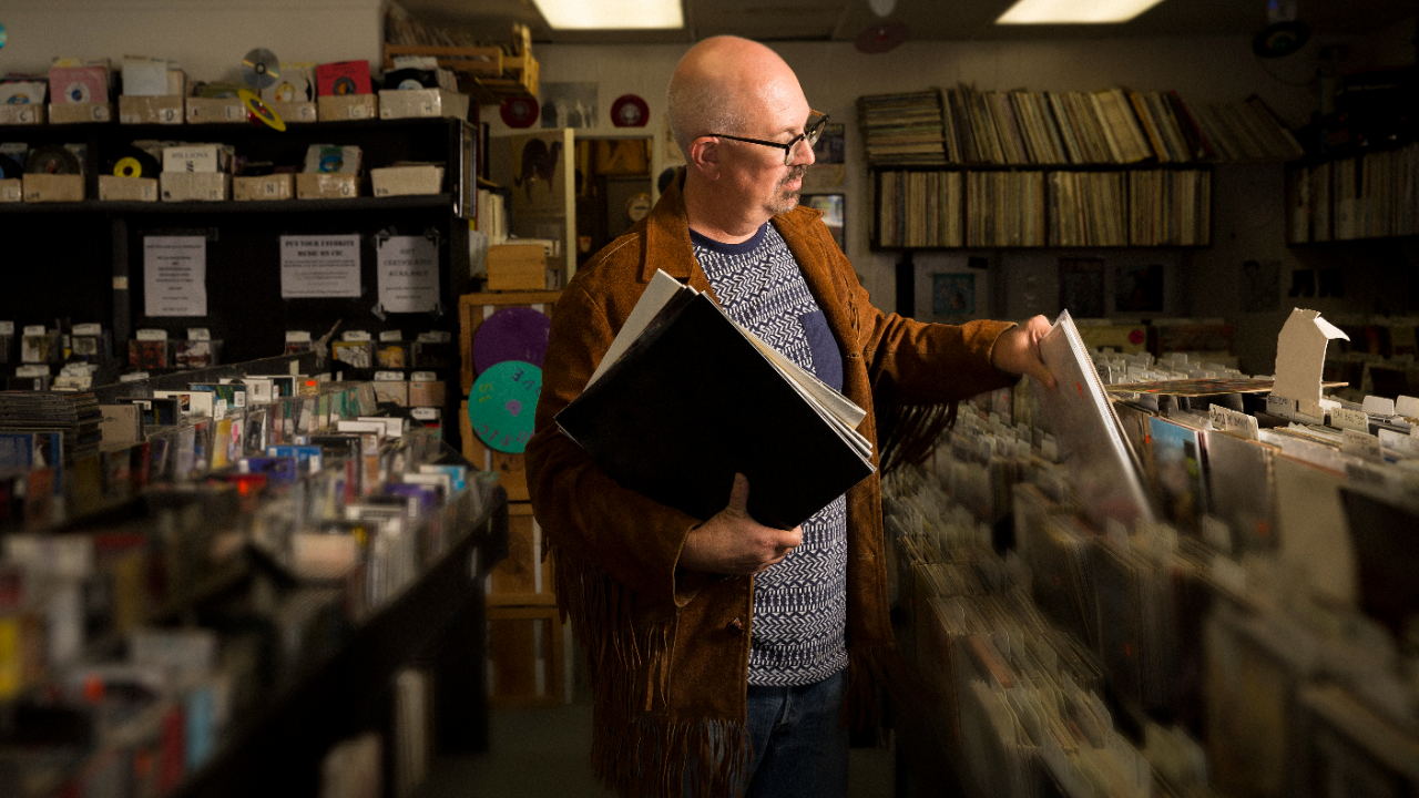 Small business owner stocking his record store.