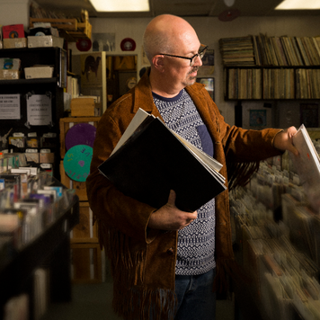 Small business owner stocking his record store.