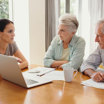 Finance, planning and senior couple discuss investment with financial advisor on a laptop at home