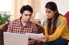 Young couple reading financial bill at home