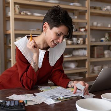 Woman calculates business revenue in her shop.
