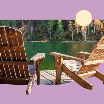 Scenic view of two wooden chairs on the edge of a lake in the forest