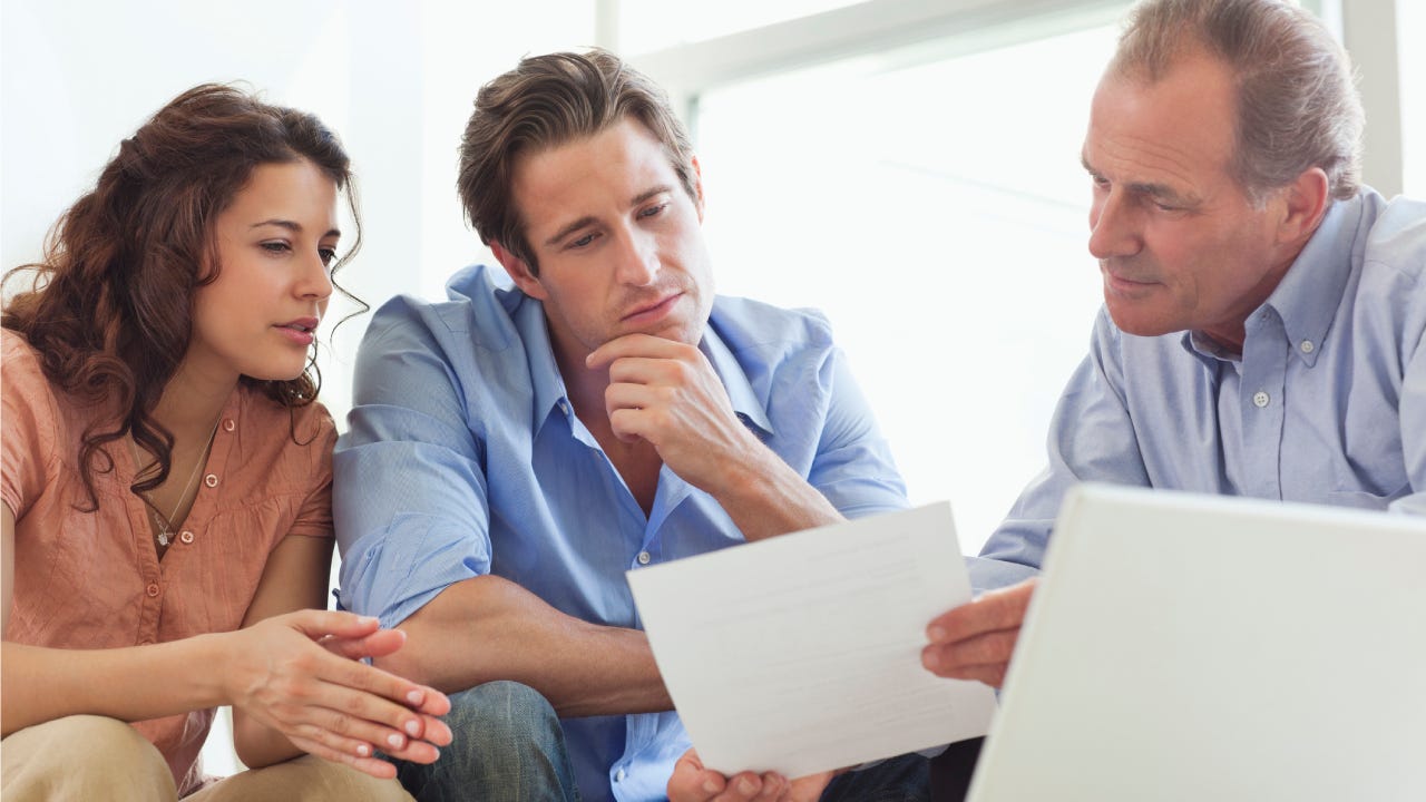 Couple going over paperwork with financial advisor