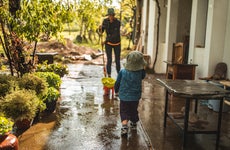 Parent and child on their patio after a storm and cleaning up