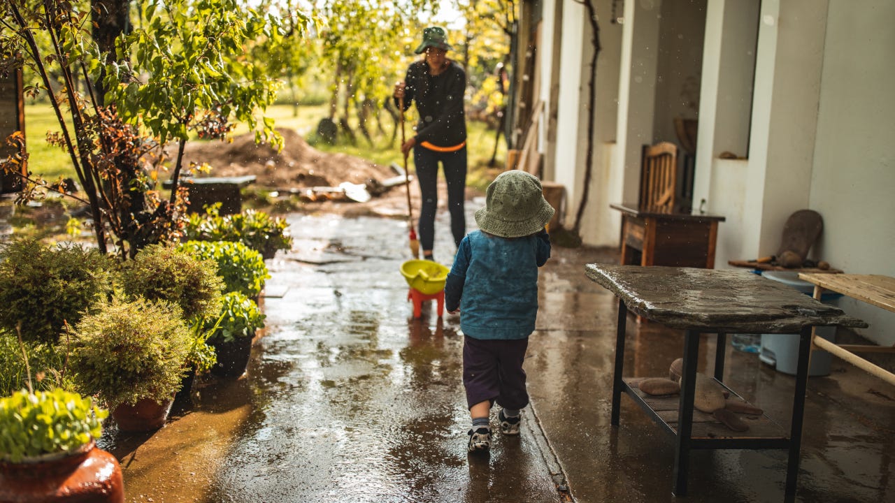 Parent and child on their patio after a storm and cleaning up