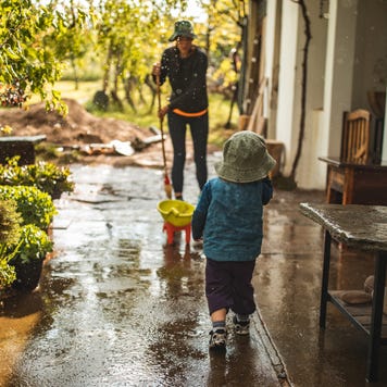 Parent and child on their patio after a storm and cleaning up