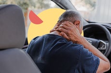 A driver massaging the back of their neck after a collision