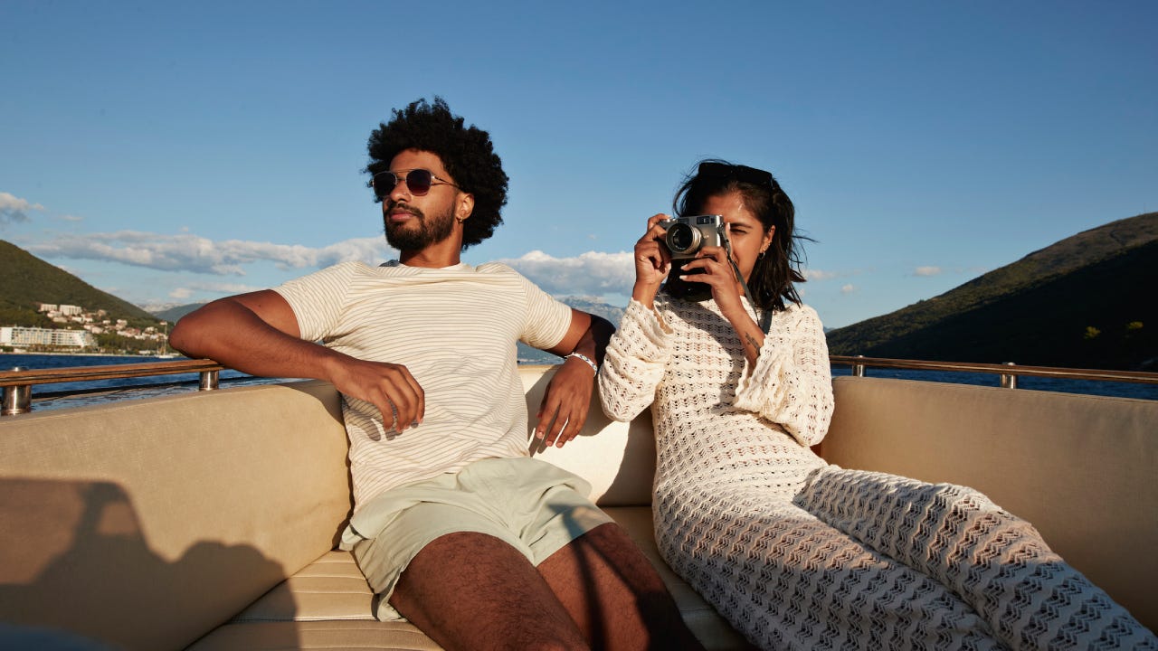 Young woman photographing on camera by boyfriend