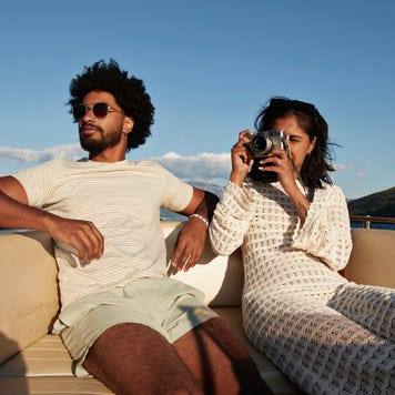 Young woman photographing on camera by boyfriend