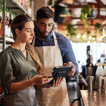 Two people review a tablet in their business