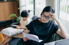 mother looking stressed while managing her financial bills
