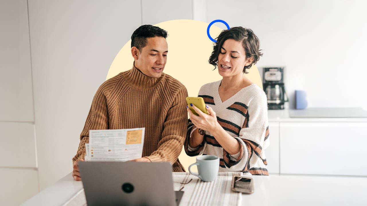 A couple standing in front of a laptop