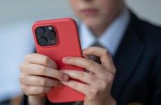 12-year-old school boy looks at a iPhone screen