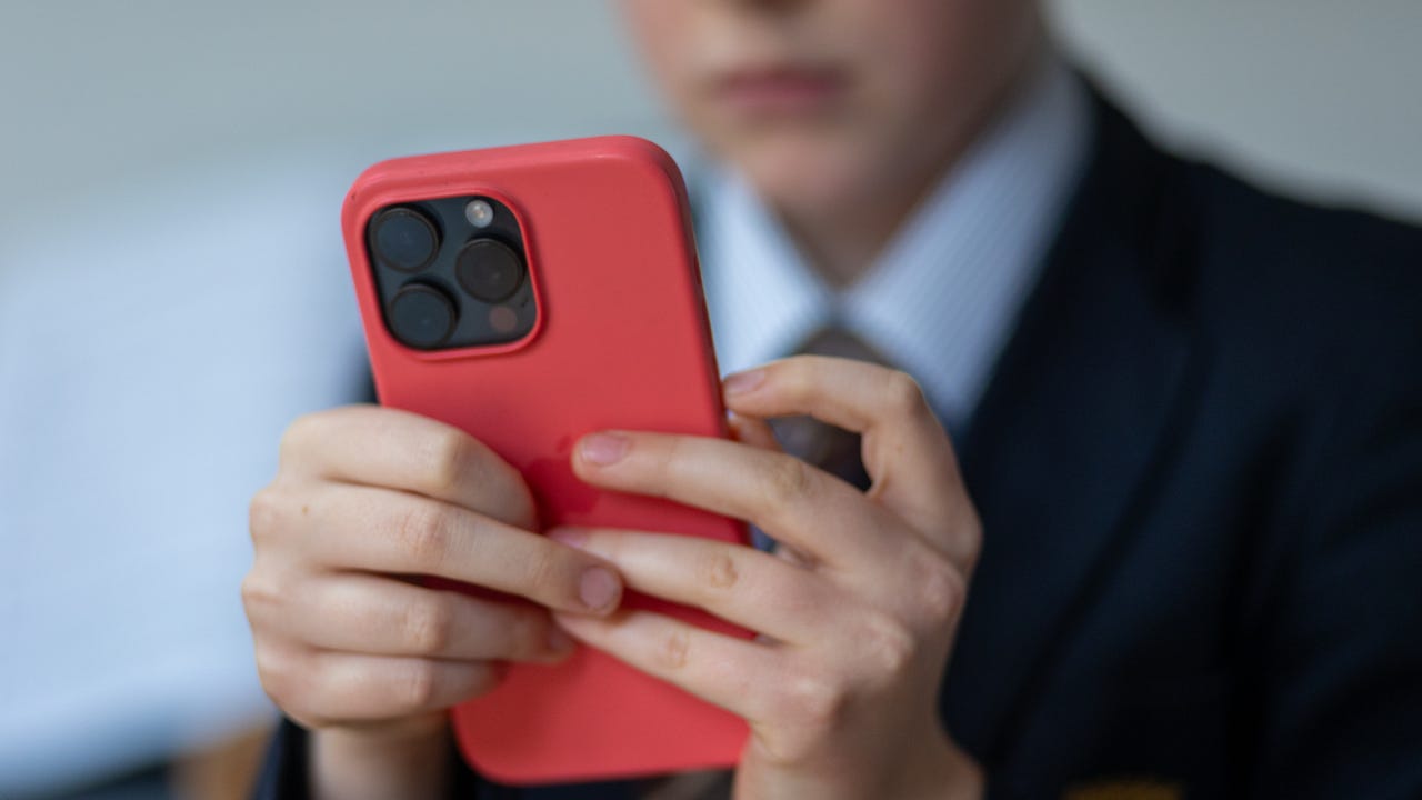 12-year-old school boy looks at a iPhone screen