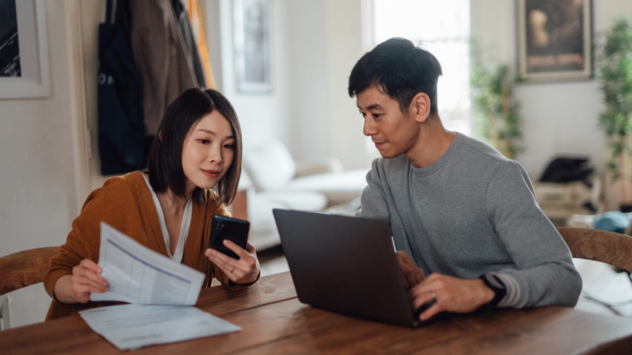Young Asian couple going through home finances