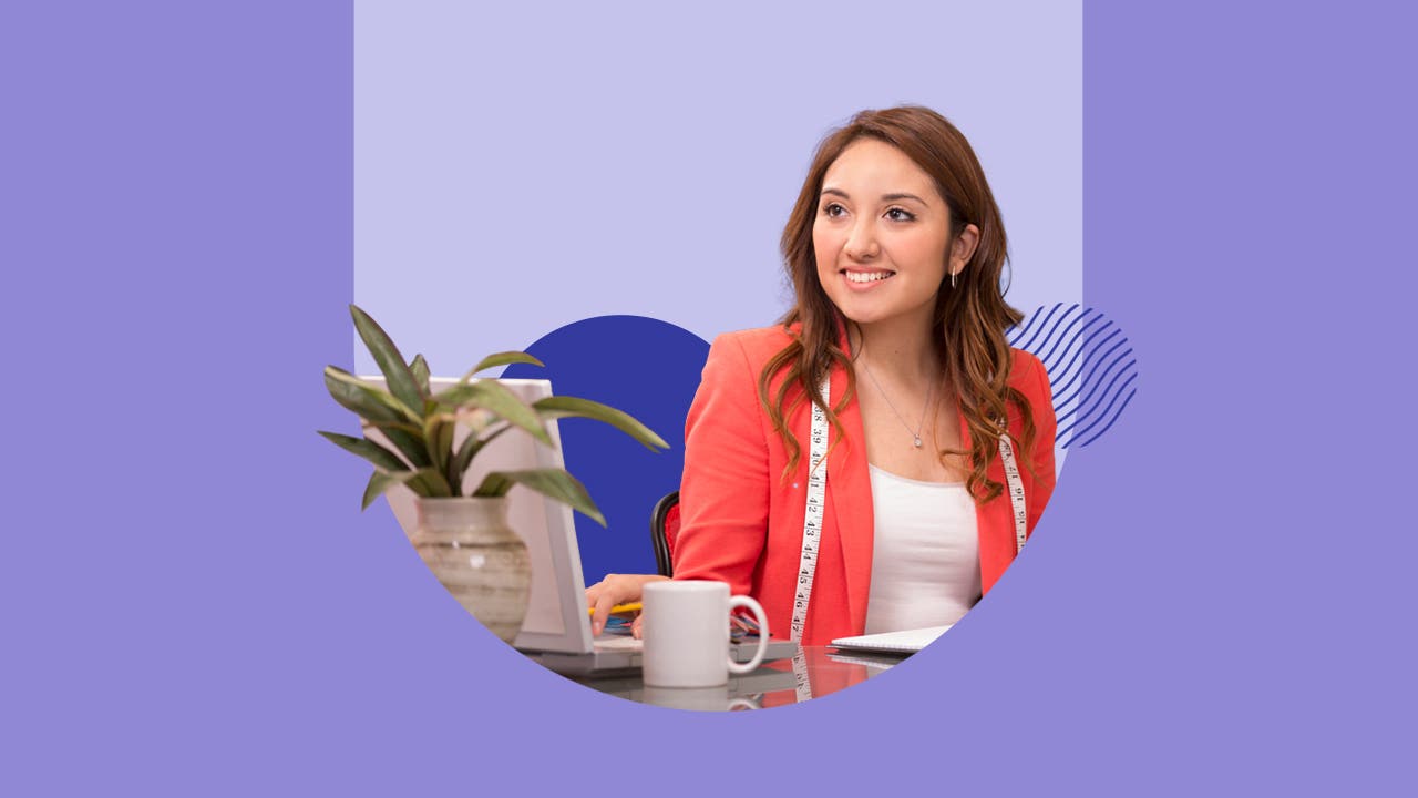 Young woman smiling and sitting next to a laptop